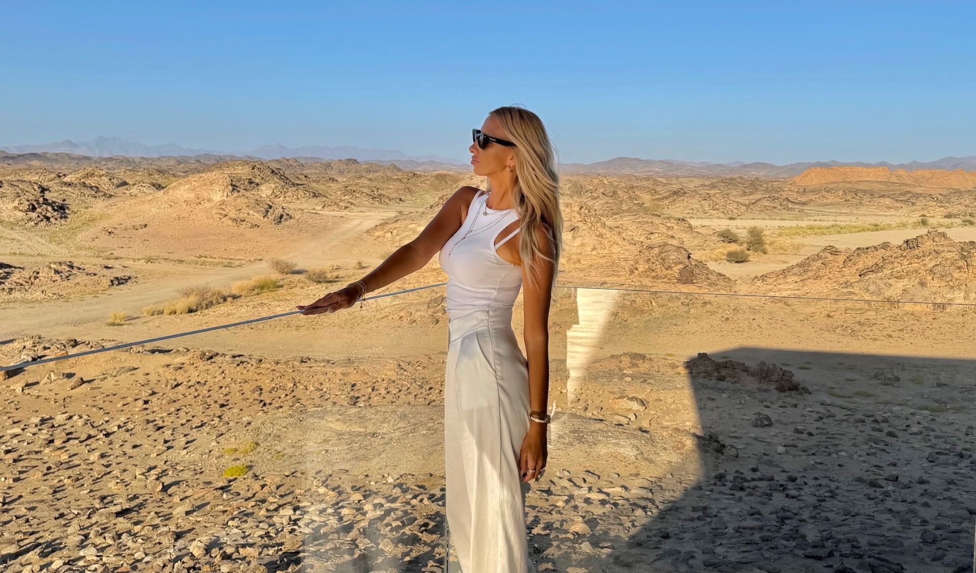 Petronela by an infinity pool overlooking the desert
